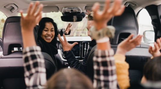 Parents engage their children inside of minivan